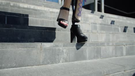 Disabled-woman-is-walking-down-the-stairs-with-a-prosthetic-leg-with-heels-on