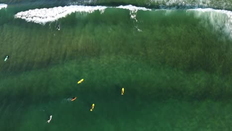 Aerial-view-of-waves-breaking-between-surfers-in-the-waters-of-Zarautz-beach