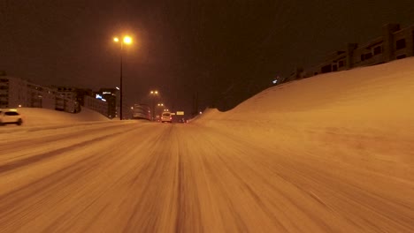 POV-driving-shot-along-snowy-Helsinki-streets-and-stopping-at-traffic-lights