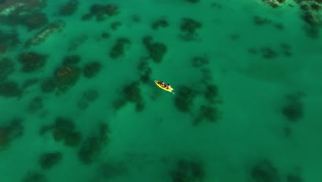 Aerial-view-around-people-paddling-in-the-Rapidos-de-Bacalar-channel,-in-Mexico---orbit,-drone-shot