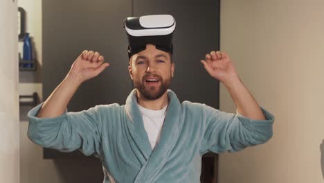 Portrait-of-a-young-man-in-a-bathrobe-wearing-virtual-reality-glasses