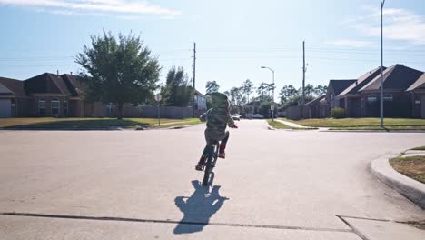 A-young-boy-riding-his-bike-in-a-neighborhood-in-4k-at-regular-speed