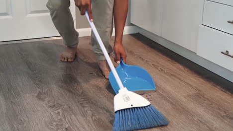 Man-is-cleaning-the-house-with-a-broom-stick,-domestic-household-maintenance-concept