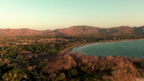 Aerial-orbit-drone-shot-of-green-waves-breaking-on-Flamingo-beach-in-sunset