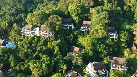 Vista-Aérea-Que-Se-Eleva-Hacia-Atrás-Con-Vistas-A-Espectaculares-Villas-En-La-Jungla-Construidas-En-La-Ladera-De-Una-Colina-Entre-árboles-En-Un-Resort-En-La-Isla-De-Pangkor-En-El-Oeste-De-Malasia