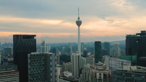 Amazing-aerial-view-of-downtown-and-city-centre-with-kuala-lumpur-tower-menara-and-sunset-in-the-background-in-Malaysia