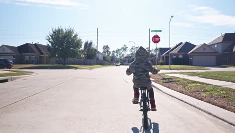 Un-Niño-Anda-En-Bicicleta-Por-Su-Barrio-A-Cámara-Lenta