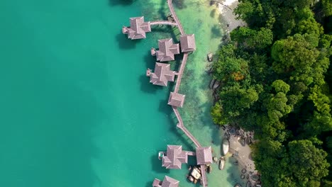 Fliegen-über-Stelzenhäuser-Und-Einen-Wunderschönen-Strand-Mit-Türkisfarbenem-Wasser-In-Einem-Resort-Auf-Der-Insel-Pangkor-Im-Westen-Malaysias