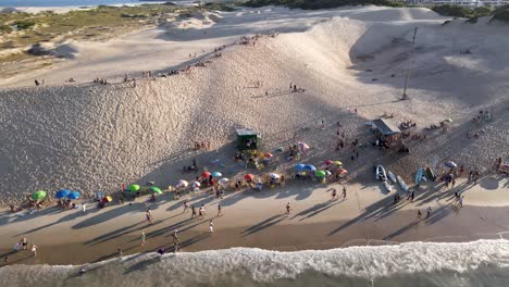 Luftdrohnenszene-Mit-Strand-Und-Menschen,-Die-Den-Sonnenuntergang-Auf-Den-Dünen-Genießen-Der-Sand-Auf-Den-Dünen-Von-Florianópolis-Brasilien-Inleses-Beach