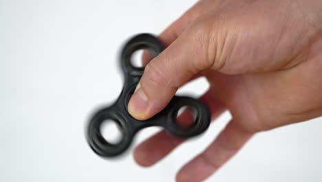 Popular-Fidget-Spinner-toy-rotating-between-fingers-of-white-man