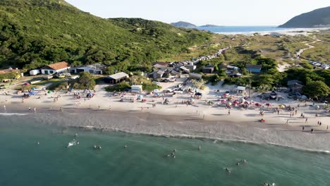 Aerial-drone-scene-with-beach-and-people-enjoying-the-sunset-on-the-dunes-and-having-fun-in-the-sand-on-top-of-the-dunes-of-Florianópolis-Brazil-in-front-ocean