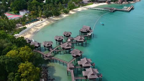 Establishing-aerial-view-of-stilt-houses-and-beautiful-beach-with-turquoise-water-at-a-resort-on-pangkor-island-in-western-Malaysia