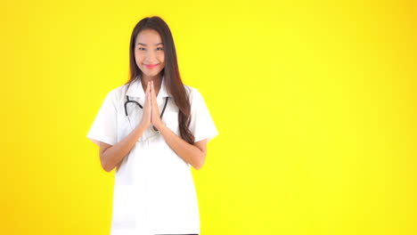 A-female-healthcare-worker-with-a-stethoscope-around-her-neck-raises-her-hands-in-the-prayer-position