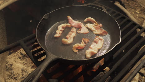 Bacon-slices-are-placed-in-a-frying-pan-that-is-heating-up-and-smoke-coming-out