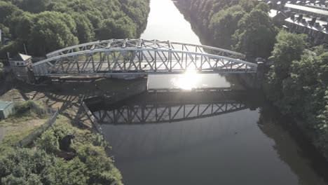Antenne-Wegziehen-Ansicht-Malerischen-Alten-Vintage-Stahl-Torbogen-Fußgängerbrücke-über-Manchester-Ship-Canal-Crossing