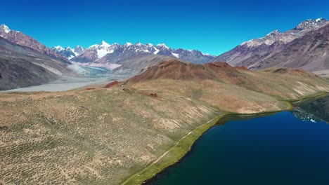 Aerial-shot-revealing-mountains-,-glacier---river-in-the-backdrop-of-chadratal-lake-,-spiti-valley