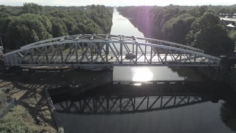 Luftbild-Auto-überqueren-Malerischen-Alten-Vintage-Stahl-Torbogen-Fußgängerbrücke-über-Manchester-Ship-Canal-Crossing