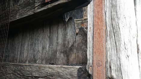 Aged-weathered-driftwood-timber-plank-door-with-rusty-neglected-old-textured-steel-supports-dolly-left