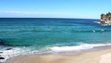 Un-Gran-Grupo-De-Surfistas-Está-Nadando-En-El-Océano-En-La-Playa-De-Bronte-En-Sydney,-Australia