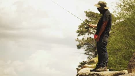 Bored-Fisherman-fishing-from-cliff-on-Big-Bear-Lake