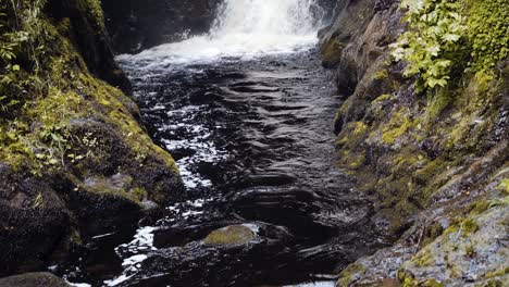 Slowmotion-pan-up-waterfall-in-Glenariff-Forest-Park,-Northern-Ireland