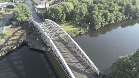 Aerial-view-scenic-old-vintage-steel-archway-traffic-footbridge-over-Manchester-ship-canal-lowering-to-crossing