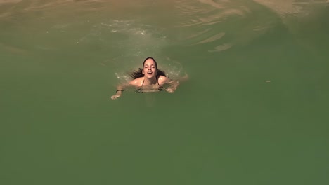 Junges-Lächelndes-Mädchen-Im-Bikini,-Der-Unter-Wasser-In-Der-Schönen-Exotischen-Sonnigen-Ozeanwasseroberfläche-Taucht