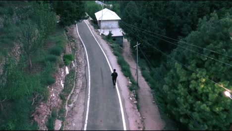 Aerial-footage-of-man-walking-in-a-hilly-area