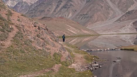 Un-Hombre-Parado-Al-Borde-De-Un-Hermoso-Lago-Himalaya