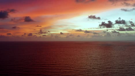 Aerial-drone-shot-of-a-stunning-golden-pink-and-orange-sunrise-with-the-vast-ocean-below-on-a-warm-summer-morning-in-Northern-Brazil-near-Joao-Pessoa
