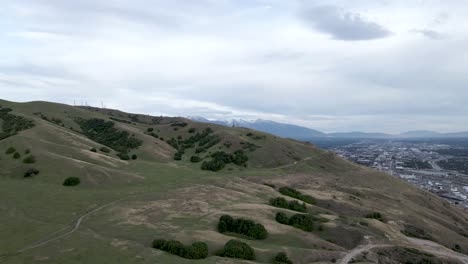 Wunderschöne-Naturlandschaft-Mit-üppiger-Wiese-Auf-Dem-Hügel-über-Salt-Lake-City-In-Utah-Unter-Dem-Dramatischen-Himmel---Aufsteigende-Drohnenaufnahme
