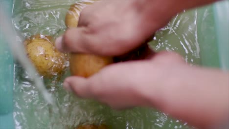 Einige-Kartoffeln-Mit-Beiden-Händen-Und-Wasser-Reinigen,-Nahaufnahme