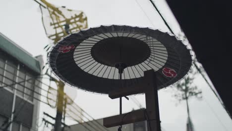Rain-Hitting-An-Umbrella-During-The-Famous-Gion-Matsuri-Festival-On-A-Rainy-Day-In-Kyoto,-Japan