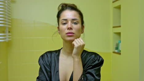 A-beautiful-young-woman-in-the-bathroom-looks-in-the-mirror