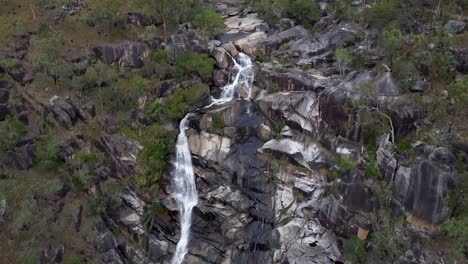 The-rocky-mountain-slope-of-Davies-Creek-Falls-in-Australia---aerial-tilt-up