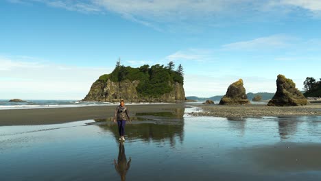 Woman-Walks-Away-from-Giant-Rocks-on-Ruby-Beach-in-Olympic-National-Park,-Washington-in-Summer