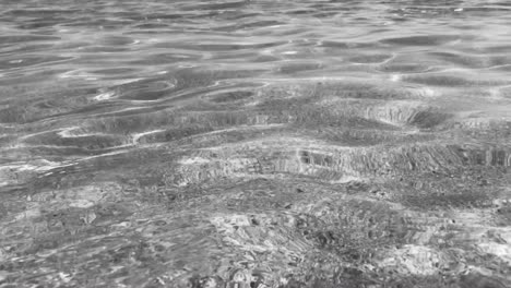Black-and-white-sea-ripples-in-4k-of-pure-crystal-clear-water-with-sandy-sea-floor