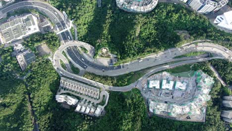 Hong-Kong-express-highway-traffic-with-Residential-buildings-and-green-nature-surroundings,-Aerial-view