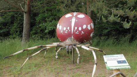 Large-Model-Of-Garden-Spider-With-Green-Trees-On-The-Background-In-Kashubian-Park-Of-Giants,-Strysza-Buda,-Poland