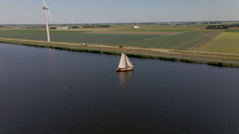 Aerial-of-boat-sailing-on-river-in-typical-Dutch-landscape