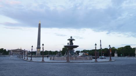 Plave-de-la-concorde-with-fountain-and-luxor-obelisk-with-fery-few-trafic-and-cars-during-early-morning-in-Paris,-arc-wide-shot
