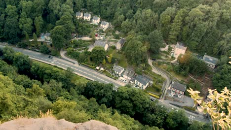Top-down-view-of-cars-traveling-on-a-small-road-through-a-village-in-Derbyshire