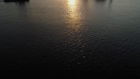 Schlepper-Und-Hydraulische-Ausrüstung-Mit-Einem-Goldenen-Sonnenuntergang-Und-Einer-Reflexion-An-Der-Ostsee-In-Darlowko,-Polen