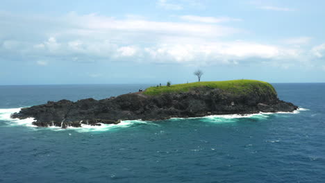 Aerial-Tracking-Shot-Of-A-Beautiful-Island-Isolated-In-Blue-Ocean-Landscape