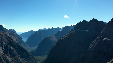 drone-shot-Milford-Sound-Gertrude-Saddle-Fiordland-National-Park,-New-Zealand-hikers-on-top