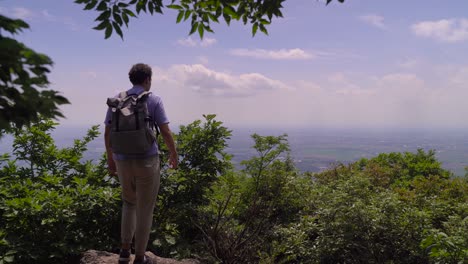 Male-Hiker-Enjoying-The-Beautiful-Views-From-Top-Of-Lush-Mountain---Medium-Shot
