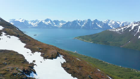 Luftaufnahme-über-Einen-Schneebedeckten-Berg,-In-Richtung-Der-Barentssee-Und-Der-Lyngen-Alpen,-Sonnig,-Sommertag,-In-Rotsund,-Troms,-Nordland,-Norwegen---Dolly,-Drohne-Geschossen