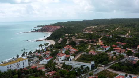 Aerial-drone-shot-of-the-small-beach-town-of-Tabatinga-near-Joao-Pessoa-in-Northern-Brazil-with-small-sand-roads,-beach-homes,-and-tropical-foliage-on-a-warm-summer-day