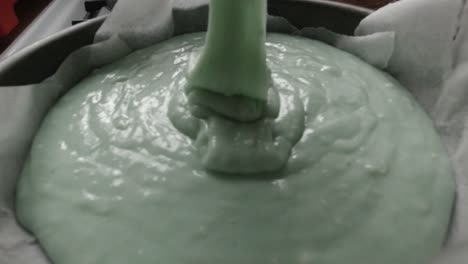 Falling-creamy-smooth-raw-cake-batter-mixture-into-kitchen-cooking-pan-slow-motion
