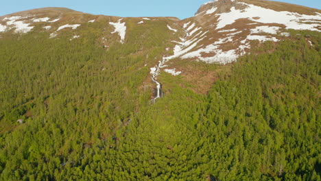 Luftbild-Zu-Einem-Wasserfall-Auf-Einem-Schneebedeckten-Berg,-Sonniger-Sommertag,-In-Rotsund,-Troms,-Nordland,-Norwegen---Absteigend,-Dolly,-Drohnenaufnahme